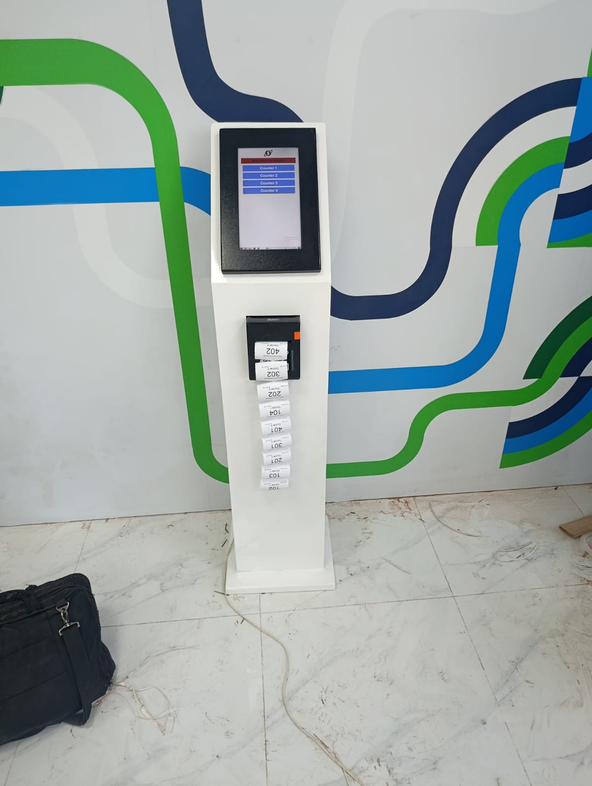 11-inch H-TECH Smart Ticket Dispenser printing a strip of tokens — Counter 1 to Counter 4 menu